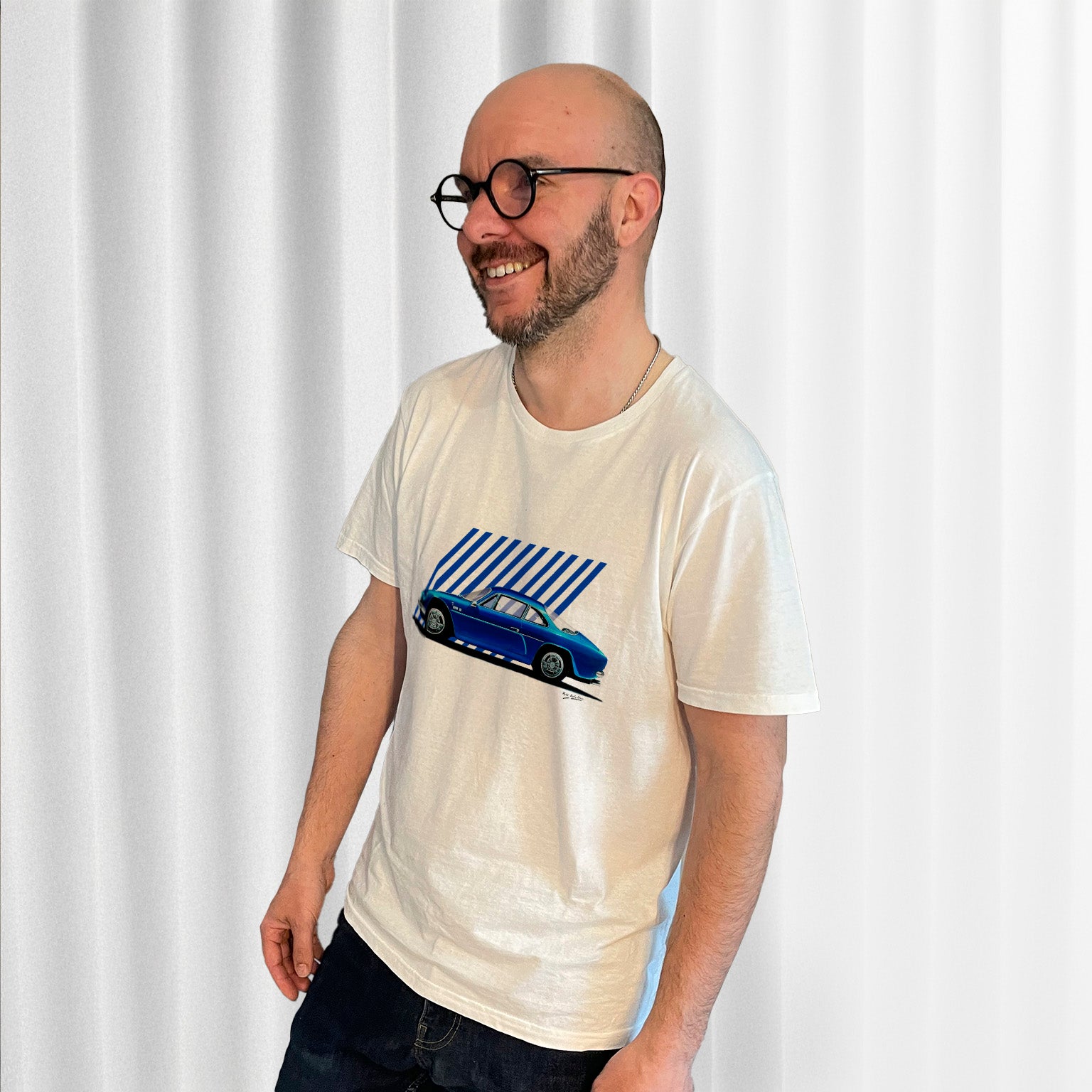 T-shirt blanc avec une superbe Alpine A110 bleue ancien modèle dessiné au milieu, porté par Matthieu Deloffre