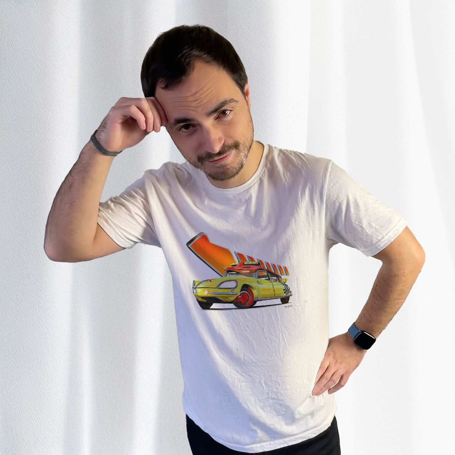 T-shirt blanc avec la DS "Hep Taxi" et la flèche orange mythique de Retour vers le Futur dessinés au milieu, porté par Corentin Gouloumy