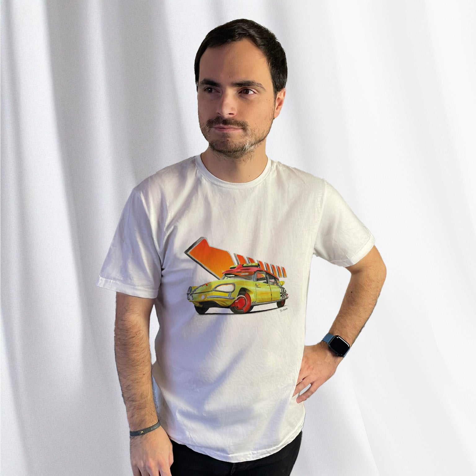 T-shirt blanc avec la DS "Hep Taxi" et la flèche orange mythique de Retour vers le Futur dessinés au milieu, porté par Corentin Gouloumy