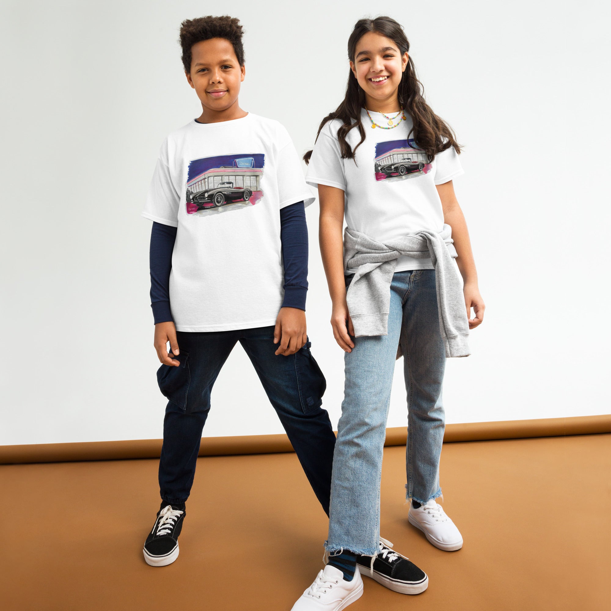 T-shirt enfant blanc avec illustration d'une BMW style Elvis Presley devant un diner, porté par des enfants