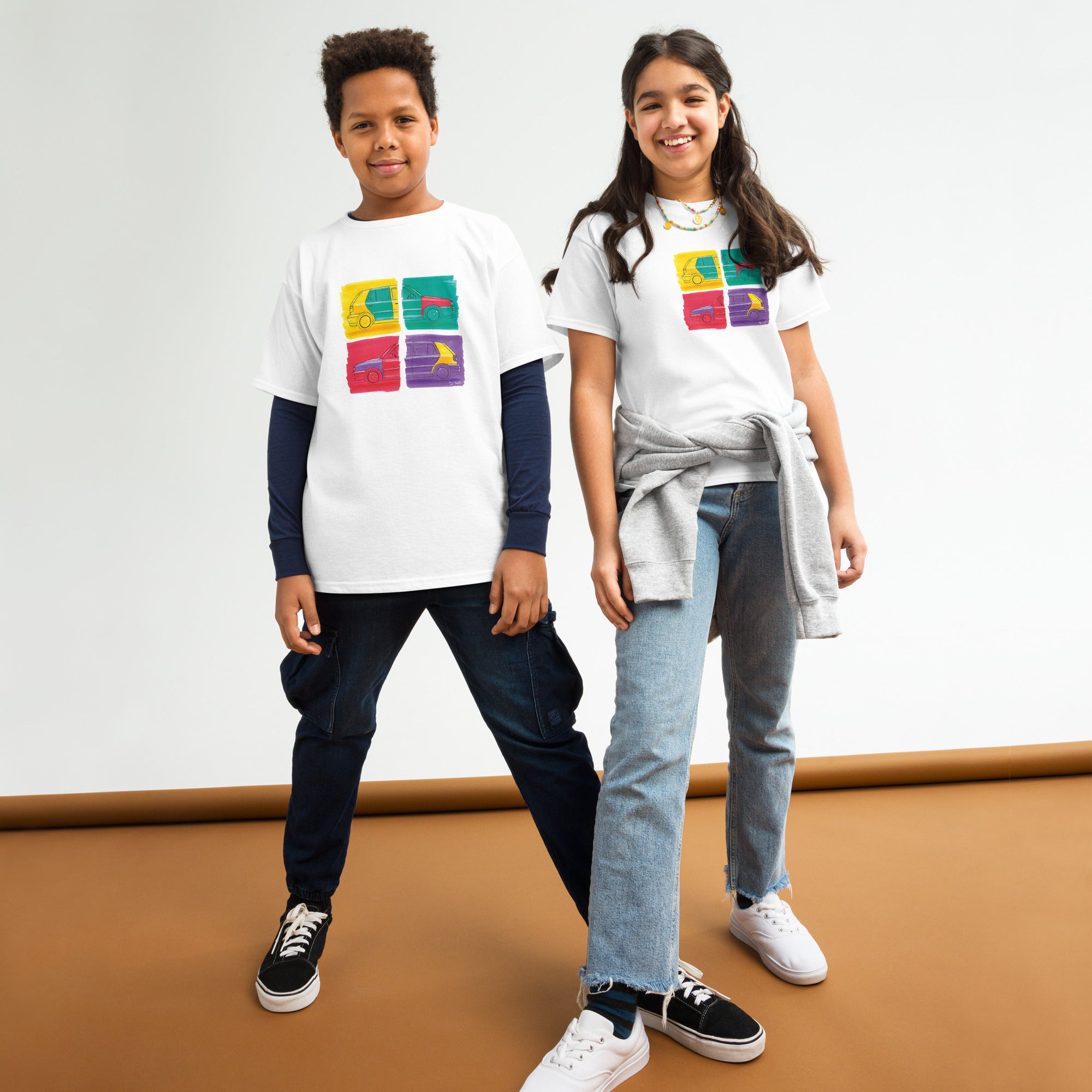 T-shirt blanc pour enfant avec au milieu une illustration représentant deux Volkswagen Golf Harlequin, de profil, dans un style Andy Warhol, porté par des enfants