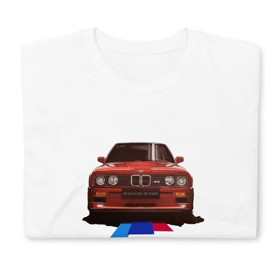 T-shirt blanc plié avec l'illustration d'une BMW M3 rouge au milieu, avec des lignes tricolores cyan, bleu et rouge partant du dessous du véhicule