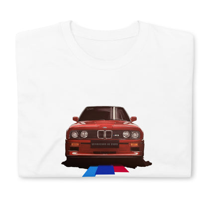 T-shirt blanc plié avec l'illustration d'une BMW M3 rouge au milieu, avec des lignes tricolores cyan, bleu et rouge partant du dessous du véhicule