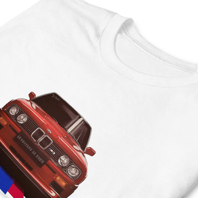 T-shirt blanc avec l'illustration d'une BMW M3 rouge au milieu, avec des lignes tricolores cyan, bleu et rouge partant du dessous du véhicule, zoom sur le motif